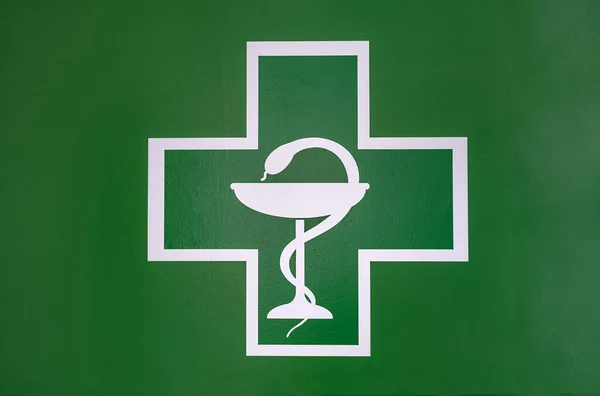 Medical Cross with the bowl of Hygeia. Modern Emblem of healthcare, medicine and pharmacy. Pharmacy symbol with snake and bowl