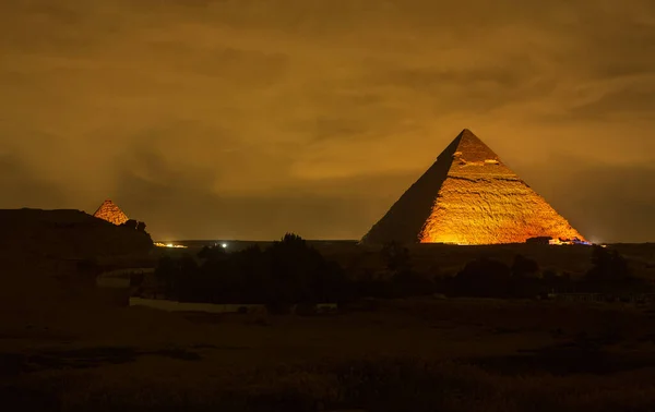 The Cheops pyramid from Giza at night. Giza pyramid illuminated at night, seen from the roof of a hotel. Pyramid of Khufu. Travel photo, nobody, copyspace for text