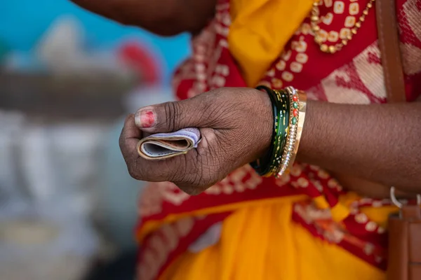 An Old Indian Women in a saree Holding Rupee Notes Of Indian Currency. Close up of hands Indian women holding money. Travel photo, street photo