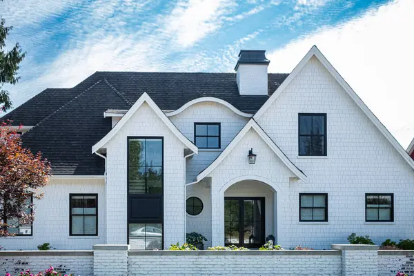 加拿大温哥华郊区的大型白色定制豪华住宅 有漂亮的前院和车库车道的大家庭住宅 免版税图库图片