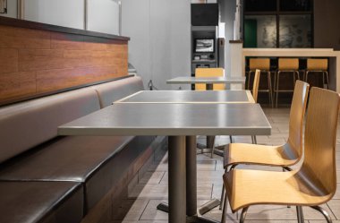 Ortak masası olan ve restoranda rahat oturan geniş bir yemek alanı. Masa Üstü Ahşap Tezgah Bar Restoranı. Ahşap mobilyalar, aydınlatma ekipmanları ve dekorasyonlu bir kafe.