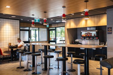 Ortak masası olan ve restoranda rahat oturan geniş bir yemek alanı. Masa Üstü Ahşap Tezgah Bar Restoranı. İçi ahşap mobilyalarla dolu kafe-Vancouver Canada-30 Haziran 2023