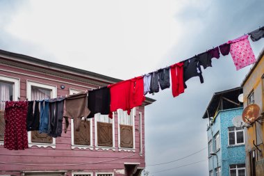 Eski şehir caddesinde çamaşır ipinde asılı. Çamaşırları asıyorum. Binalar arasında çamaşırları yıkadım. Kuru giysiler dışarıda asılı. Fakir bölge. İpin üstünde çamaşır kurutma.