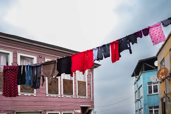 Laundry hanging on a clothes line in old city street. Hanging Laundry. Washed clothes on lines between buildings. Drying clothes hanging outside. Poor district. Laundry dryings on the rope