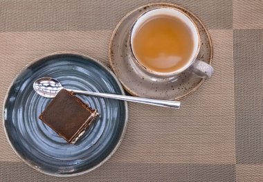 Bir fincan çay ve lezzetli bir pasta. Masada tiramisu kekleri ve çay ile kompozisyon, üst manzara. Çikolatalı kekle bir fincan çay.