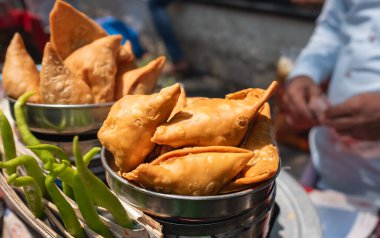 Sebze dolgulu kızarmış samosalar, sokak pazarında satılan popüler Hint atıştırmalıkları. Sokaklarda atıştırmalıklar, Patates Samosa Atıştırmalıkları, Vejetaryen Samsa veya Samosa. Hint özel geleneksel sokak yemekleri.