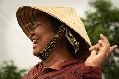 Çiftçi kadın pirinç tarlasında gülüyor. Çeltik tarlasında mutlu bir Vietnamlı çiftçinin portresi. Vietnam şapkalı kadınlar Non la. 1 Nisan 2024-Nha Trang Vietnam