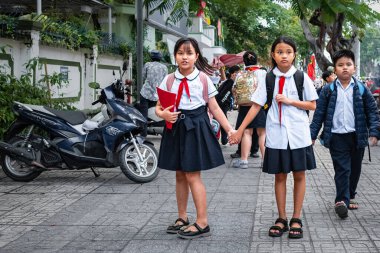 Dersten sonra okuldaki genç çocuklar. Sokaktaki genç Vietnamlı liseli kızlar. Kırmızı kravatlı Vietnamlı okul üniformalı çocuklar. Editör, sokak fotoğrafı - Nha Trang-Mart 28. 2024