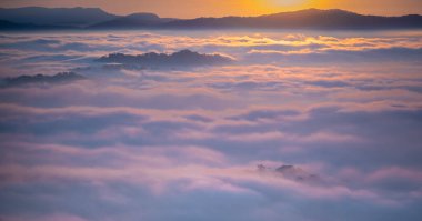 Yükselen güneş bulutların ve dağların altında parlıyor. Dalat Vietnam 'da sabah doğan güneşin güzel manzarası. Bulut avı.