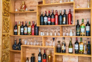 Da Lat Vietnam 'daki bir barın raflarında farklı şişelenmiş alkol türleri sergileniyor. Farklı içki şişeleri olan raflar. Restoranda şarap koleksiyonu var. Şarap şişeleri - 15 Nisan 2024