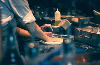 Eller pizza yapmak için hamur yoğurur. Pizza şefi restoranda pizza hamuru yapar. Çiğ pizza hamuru. Şefin pizza yaparken yakın çekim görüntüsü..