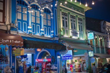 Phuket, Tayland. Phuket Eski Kasabası 'ndaki eski Çin-Portekiz binaları ve sokaklarda dolaşan turistlerin olduğu gece manzarası. Işıkları olan eski kasabadaki dükkanlar ve restoranlar. 18 Temmuz 2024
