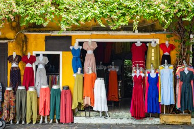 Renkli yaz kıyafetleri mağazada satılık. Mankenlerin dışındaki bir giyim mağazasında çeşitli ürünler. Kadın kıyafetleri. Moda endüstrisi. Kadın caddesindeki bir butikte şık kıyafetler..