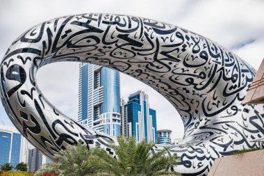 Dubai 'nin ünlü Şeyh Zayed Yolu' na bakan Torus şekilli Gelecek Müzesi 'nin dış metalinde kabartmalı Arapça kaligrafi var.