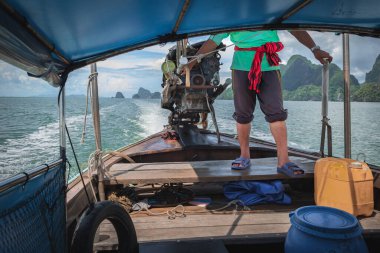 Phuket Tayland 'da bir yaz günü direksiyon sallayan adamın portresi. Balıkçılar Tayland 'da geleneksel uzun kuyruk teknesi kullanırlar. Seyahat fotoğrafı.