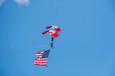 Canadian skydiver with Canadian and American flag. Abbotsford, Canada BC, Abbotsford Airshow 2023. the Canadian International Air Show in North America. Paratrooper Canadian Army forces. clipart