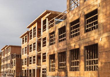 Mavi gökyüzüne karşı çerçevelenen yeni konut inşaatı. Çatı inşaatı. Ahşap yapım. İnşaat halindeki yeni ahşap bir evin çerçevesi. Modern tasarım Mimari. Kanada BC