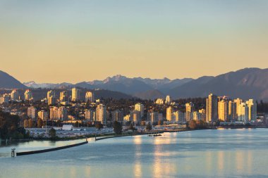 Yeni Westminster, BC Kanada. Gün batımında New Westminster şehir merkezinde. Fraser nehri ve arkasında dağlar olan şehir manzarası. Şehir manzarası,