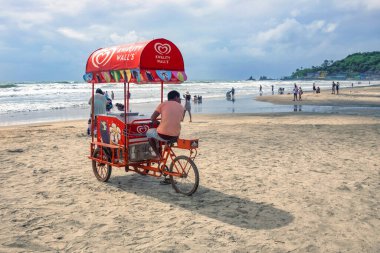 Kuzey Goa 'daki Arambol plajı manzarası. Palmiye ağaçlı Arambol plajı, Hint ve yabancı turistli plaj şemsiyeleri. Nort Goa 'nın popüler turistik merkezi. Seyahat fotoğrafı, uzayı kopyala. 7 Eylül 2024