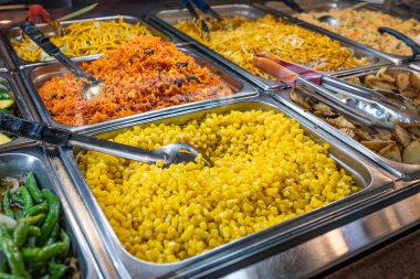 Süpermarkette sıcak yemek barı. Aşçı dükkânı vitrini. Yerel Store Foods Market 'teki tepsilerdeki Hot Bar yiyeceklerinin yakınlaştırılması. Süpermarkette çeşit çeşit yiyecekler var. Aperatif çeşitleri.