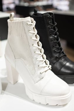 Rafta şık deri çizmeler. Şık kadın ayakkabıları satan bir mağaza. Savaş botları. Klasik sonbahar çizmeleri. Deri ayakkabı bağcıkları. Kış havası için sıcak, dantelli botlar.