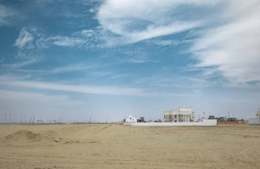 Çölde yeni evler inşa etmek. Geliştirme mimarisi. Suudi Arabistan 'da mavi gökyüzü arka planına sahip geleneksel Arap çamur evleri. Çölde kulübe binaları inşa ediliyor.