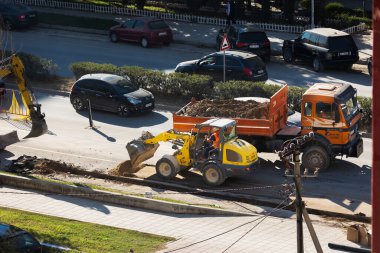Çamurlu bir kamyon ve kazıcı makinesiyle yol inşaatı için beton döşeme. Yol çalışmaları, yol inşaatı. Yol kapanıyor. Arnavutluk, Vlore, 7 Kasım 2024