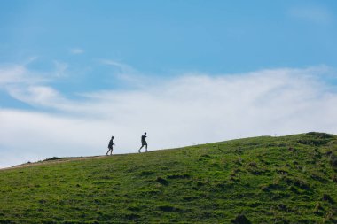 Güneşli bir günde tepeye tırmanan bir çift. Tatilde olan çift dışarıda faaliyet gösteriyor. Arnavutluk 'ta kadınlar ve erkekler tepede yürüyor, Vlore. Seyahat konsepti, uzayı kopyalamak. 7 Kasım 2024