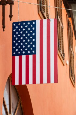 Bir evin önünde ABD bayrağı sergileniyor. Bir binanın ön cephesinde asılı Amerikan bayrağı. Amerikan bayrak yıldızlarına ve çizgilerine yakın çekim. Vatanseverlik, ulusal kimlik ve ülke konseptine duyulan sevgi.