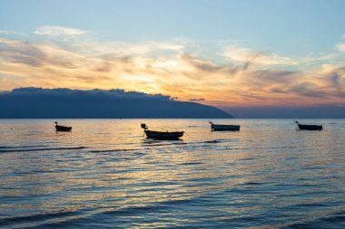 Vlore Arnavutluk 'taki İyon Denizi üzerinde günbatımı manzarası. Dalgalanan güzel sular, sakin dalgalar ve balıkçı tekneleri. Yatay fotoğraf. Uzayı kopyala Seyahat fotoğrafı..