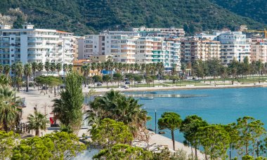 Arnavutluk 'un deniz kenarı ve modern mimarisi ile Vlore panoramik kent manzarası. Güneşli bir yaz gününde Adriyatik Denizi kıyısında bir şehir. Düz binaları olan bir apartman dairesi. Seyahat kavramı