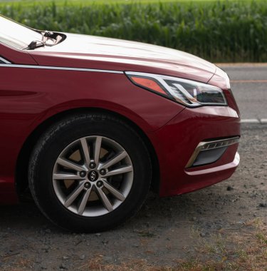 Kore orta boy sedan Hyundai Sonata 'nın ön tekerleğinin ayrıntıları. Yolun ortasına Hyundai Sonata marka orta boy bir araba park etmiş. Ön manzara ve farlar. Hiç kimse, editör-Vancouver Kanada-Temmuz 15.2021