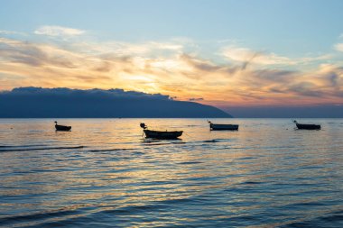 Vlore Arnavutluk 'taki İyon Denizi üzerinde günbatımı manzarası. Dalgalanan güzel sular, sakin dalgalar ve balıkçı tekneleri. Yatay fotoğraf. Uzayı kopyala Seyahat fotoğrafı..