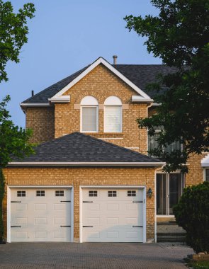 Güneşli bir günde gayrimenkul paravanı. Banliyöde garaj yolu olan lüks bir ev. Modern tasarım ev, inşaat evi dış görünüş