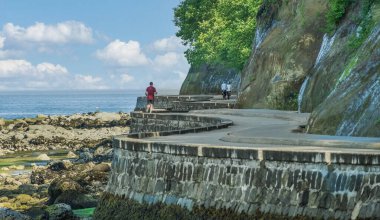 Vancouver Kanada 'nın kuzey Vancouver manzaralı deniz duvarı parkı. British Columbia 'daki liman kenarı Stanley Parkı. Seawall yürüyüşü. Rıhtım yolu. Yürümek ve bisiklet sürmek için patika.