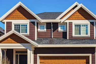 Facade of a house with nice windows in the blue sky background. Beautiful Home Exterior. Real Estate Exterior Front House in a residential neighborhood. Nobody, street photo, copy space for text clipart