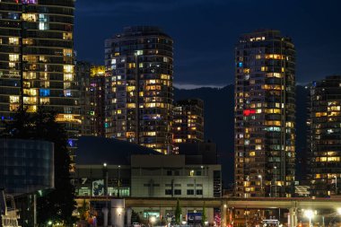 Vancouver şehir merkezi, geceleri Modern Şehir Manzarası, uzun pozlama. Vancouver British Columbia Canada 'daki False Creek körfezinin doğu kıyısındaki City Lights in the Evening. Seyahat fotoğrafı - 1 Ocak 2022