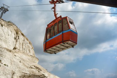 Mavi gökyüzüne yükselen bir teleferik ve arka planda beyaz bulutlar. Rosh Hanikra 'daki turistler, kayakçılar ve snowboardcular için teleferik İsrail' i mağlup ediyor. Dağ taşımacılığı ve turizm kavramı. Boşluğu kopyala