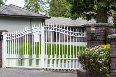 Çift işlemeli demir kapı. Demir kapı ve taş sütun satmış. Beyaz dövmeli demir giriş kapıları. Lüks bir evin metal çit kapısı. Ağır metal ön kapı. Hiç kimse, sokak fotoğrafı.