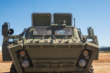 Eğitim sahasında zırhlı araç. Amerikan askeri ekipmanları. Yeşil kahverengi kamuflaj desenli askeri araç. Tatbikatta askeri çokgen üzerine tekerlekli zırhlı araç