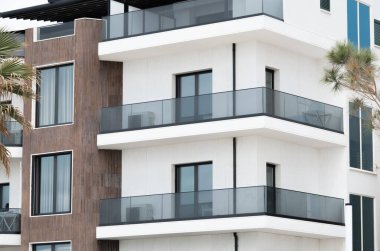 Avrupa Mimarlık Konutları. İnşaat endüstrisi. Modern apartman binası. Mimarlık, balkonları ve pencereleri olan modern cephe binasının detaylarını anlatıyor. Karmaşık apartman dairesi.