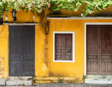 Eski bir Asyalı evi cephesi. Hoi An 'da geleneksel sarı evleri olan sokaklar. Eski bir kasaba. Eski şehrin merkezindeki renkli tarihi binalar. Seyahat fotoğrafı, kimse yok.