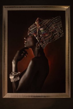 Güzel siyah kadın portrenin çerçevesinde bir model. Duvarda asılı duran genç ve güzel bir Afrikalı kadının portresi. Editör, seçici odak, Tiran Arnavutluk-8. 2025