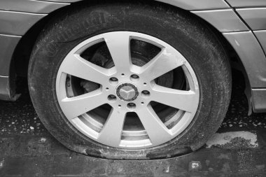 Arabanın lastiği patlamış, yolda hava lastiği basıncı düşmüş. Mercedes Benz 'in arka lastiği patlamış, lastiği patlamış. Metal bir disk-Tiran Arnavutluk-Apr 8. 2025 plakalı lastiği delinmiş bir araç.