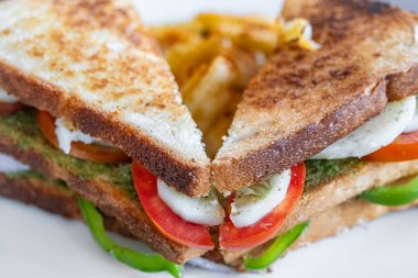 Yakın plan peynirli ve domatesli sandviç. Tavada erimiş peynirli tost ekmeği, üst manzara. Hiç kimse, seçici odaklanma. Kahvaltı konsepti