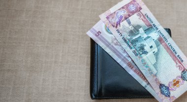 Farklı Dirhams para birimlerini kapatın. Birleşik Arap Emirlikleri 50 Dirhem nakit para birimi. Birleşik Arap Emirlikleri merkez bankası siyah bir cüzdana 50 dirhem para koydu. Boşluğu kopyala