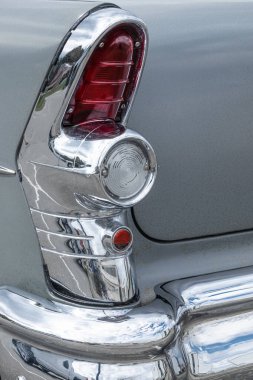 Vintage Car 'ın arkasında. Klasik araba arka farlarına yakın çekim. Antika bir aracın stop lambaları. Arka kanadın ayrıntıları ve arabanın fren lambaları. Sokak fotoğrafı, kimse yok.