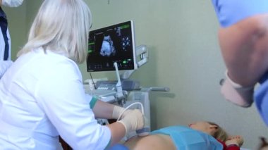 KYIV, UKRAINE - FEBRUARY 8, 2022: Amniocentesis. Amniotic fluid test. Ultrasound examination of the fetus of a pregnant woman. Ultrasonic scanner.