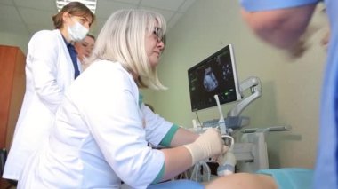 KYIV, UKRAINE - FEBRUARY 8, 2022: Amniocentesis. Amniotic fluid test. Ultrasound examination of the fetus of a pregnant woman. Ultrasonic scanner.