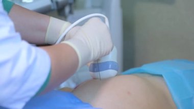 KYIV, UKRAINE - FEBRUARY 8, 2022: Amniocentesis. Amniotic fluid test. Ultrasound examination of the fetus of a pregnant woman. Ultrasonic scanner.